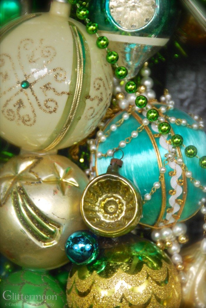 An even closer look at the pin art ornament plus a very old glass ornament with a comet on it and a fun but elegant plastic ball on top.